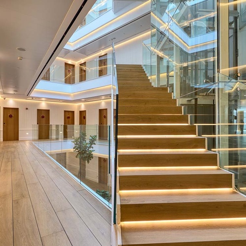Modern Ybarra Sevilla hotel with glass-railed stairs and atrium.
