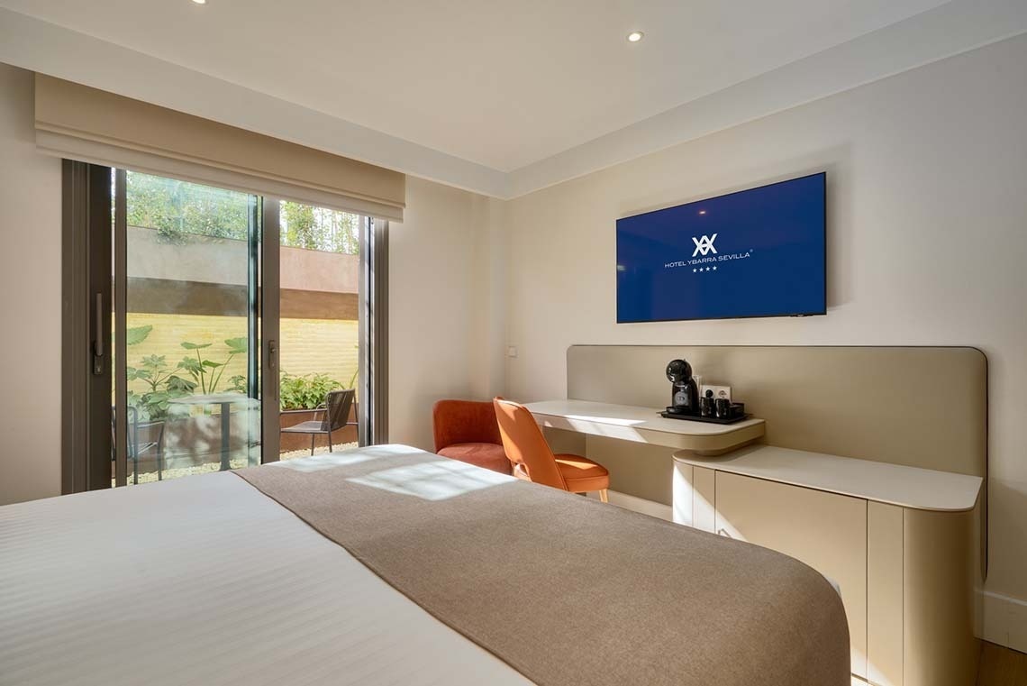 Una moderna habitación de hotel con cama, televisor mostrando el logo 