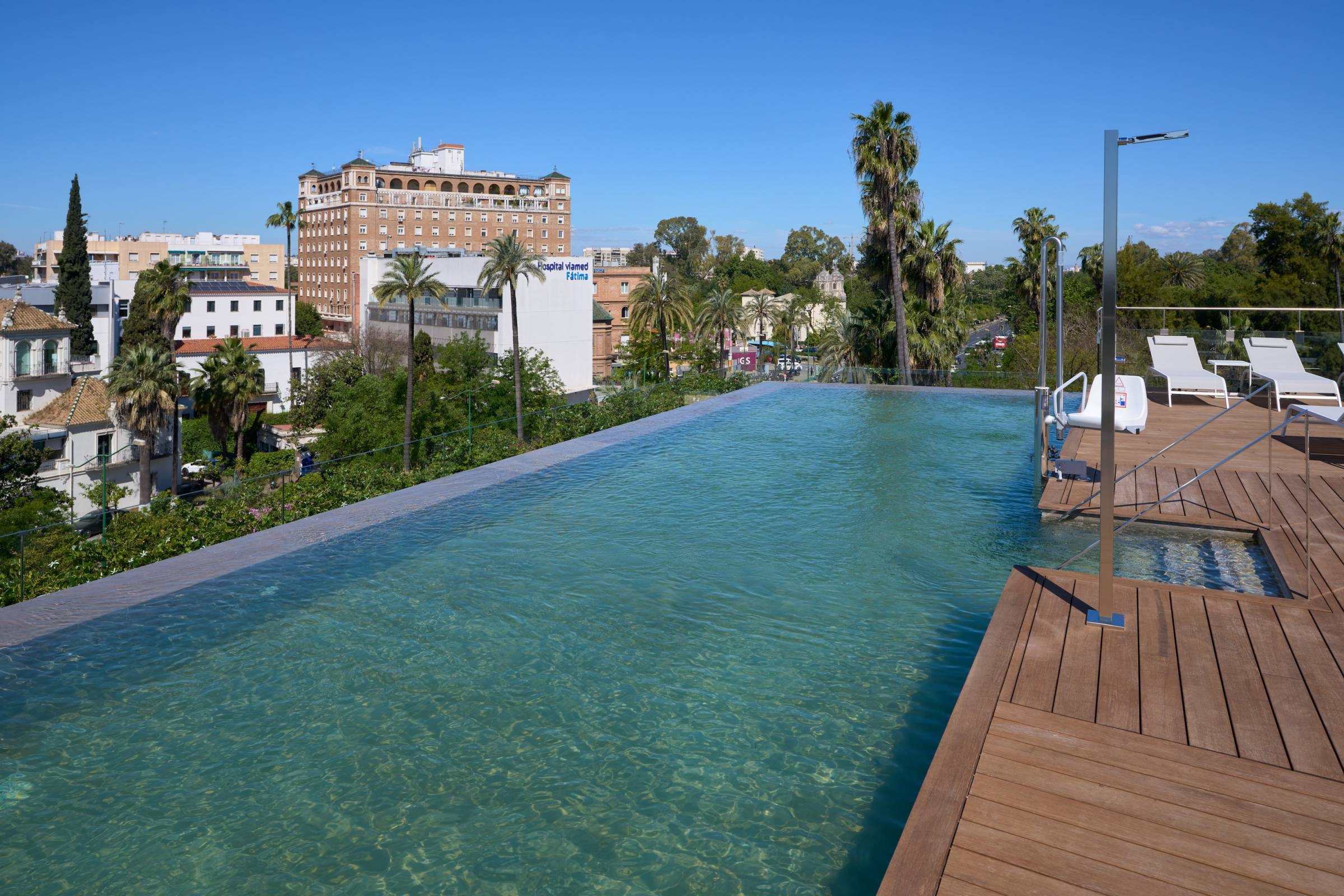 Luxury infinity pool with city views at Hotel Ybarra Sevilla.