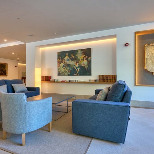 Elegant Ybarra Sevilla lounge with plush seating, art, and a crest.