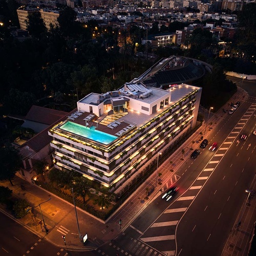 Rooftop pool at Ybarra Sevilla hotel, illuminated at night with city views.
