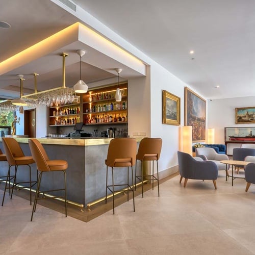 Modern bar and lounge at Hotel Ybarra Sevilla, featuring comfortable seating and an outdoor view.