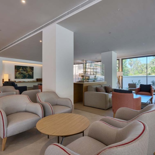 Elegant lounge at Hotel Ybarra Sevilla with sofas and coffee tables.
