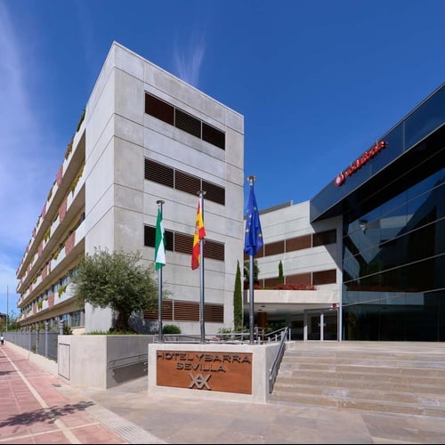 Hotel Ybarra Sevilla: modern facade, stairs, and a sign with the hotel's name.
