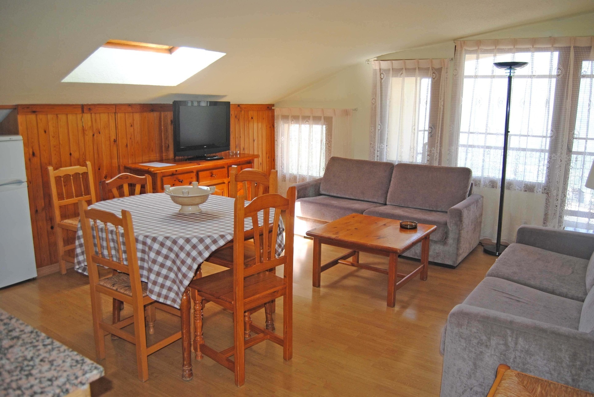 a living room with a table and chairs and a flat screen tv