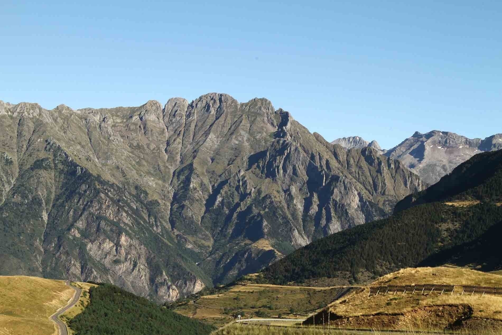 una carretera pasa por un valle rodeado de montañas