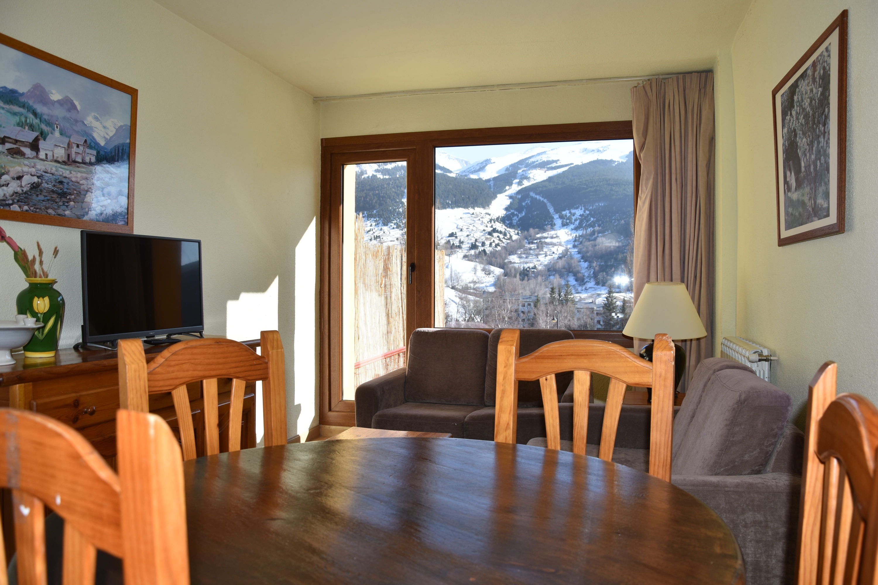 una sala de estar con una mesa y sillas y una televisión