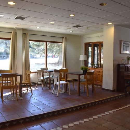 a room with tables and chairs and a piano