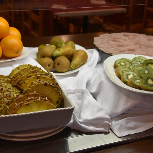 a tray of pineapple slices sits next to a bowl of kiwi slices