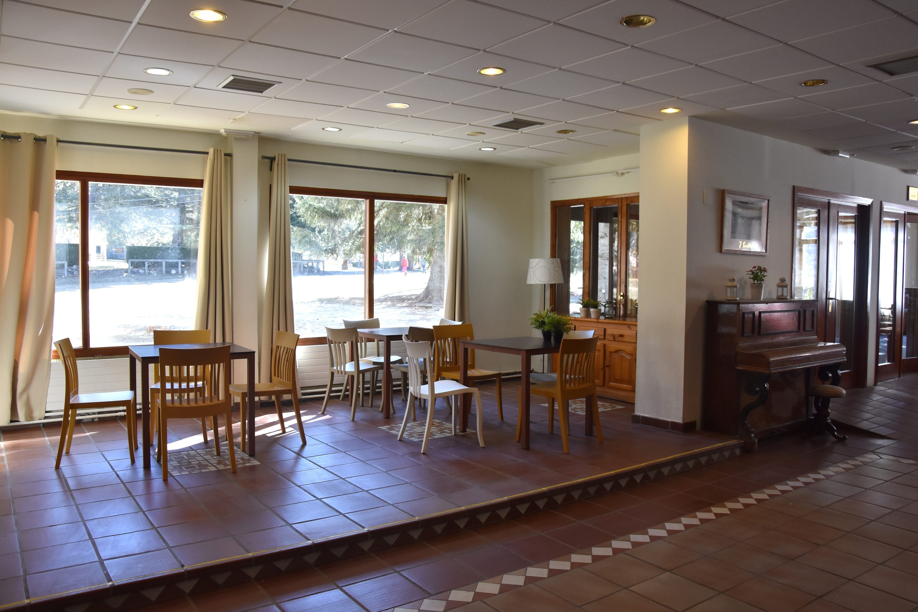 a room with tables and chairs and a piano