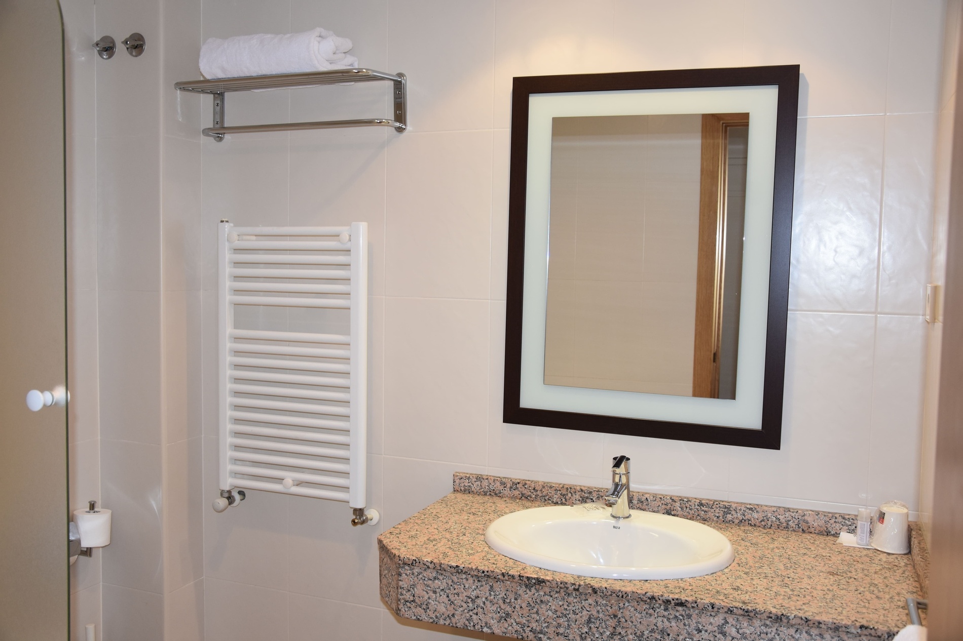 a bathroom with a sink a mirror and a towel rack