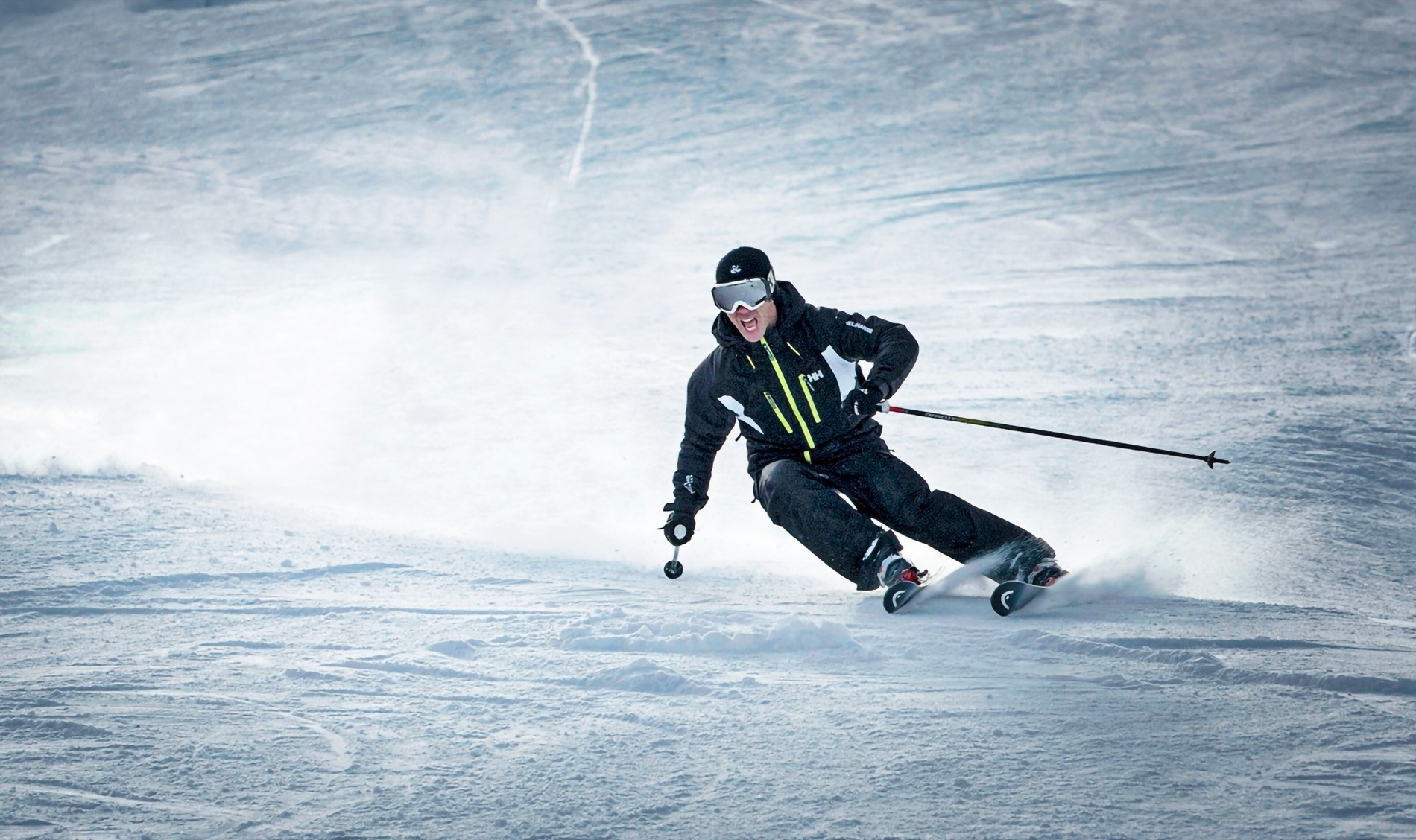 a man skiing down a snowy slope wearing a hh jacket