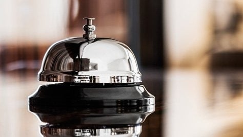 un homme avec des valises se tient à la réception d' un hôtel