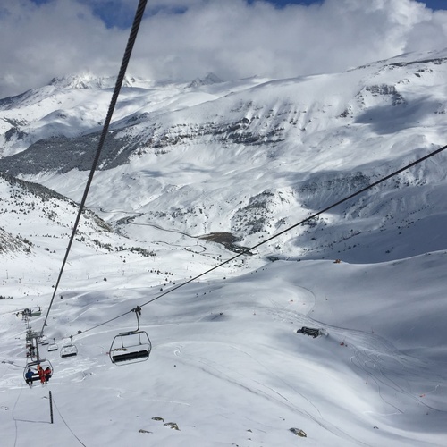 a ski lift going up a snow covered mountain