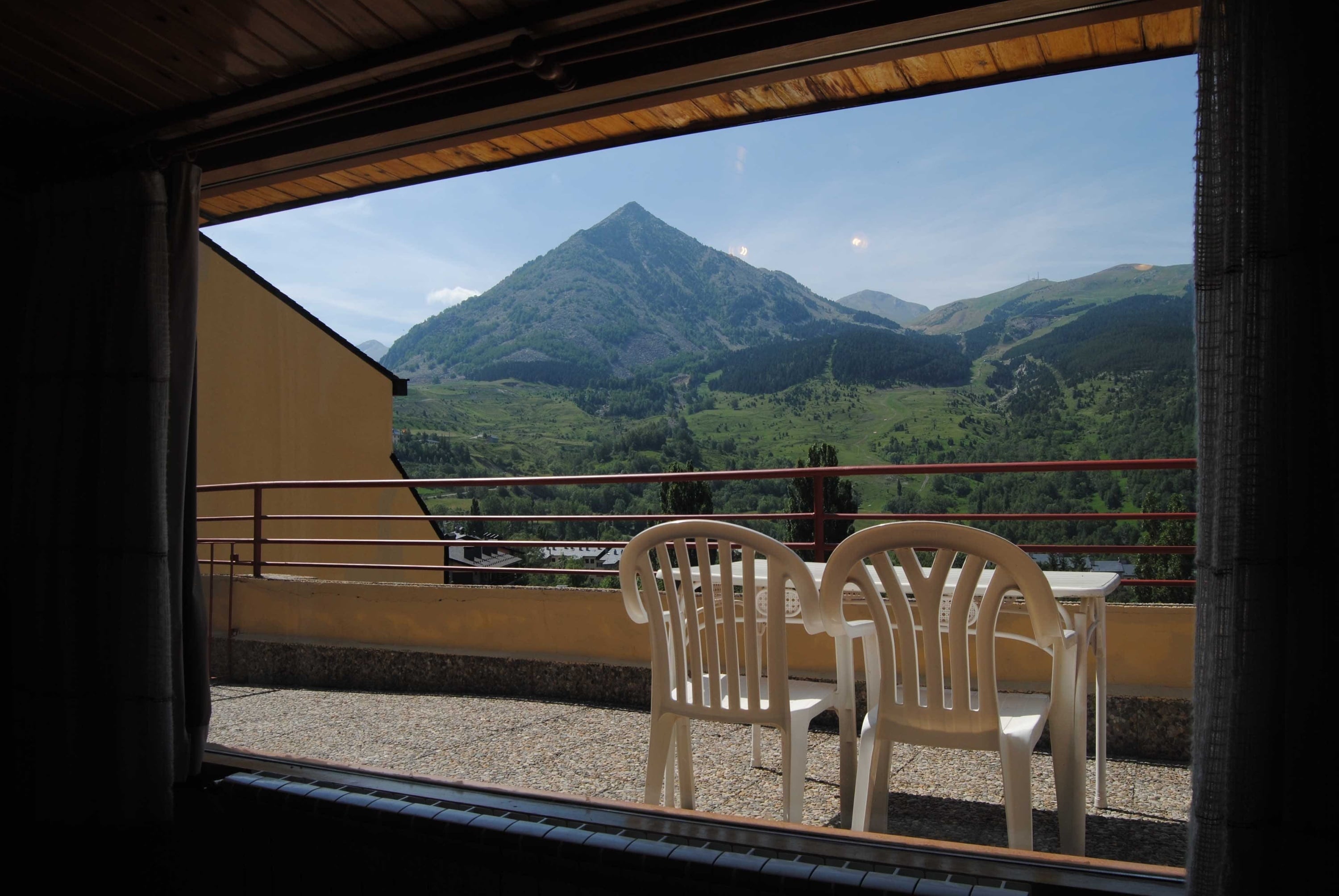 una sala de estar con una mesa y sillas y una televisión