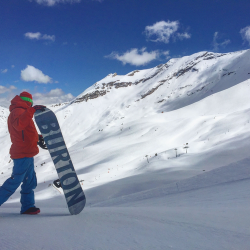 Snowboarder with Burton board at SNO: Edelweiss, snowy mountains.
