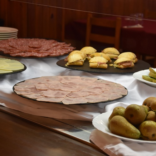 a buffet table with a variety of food including sandwiches and pears