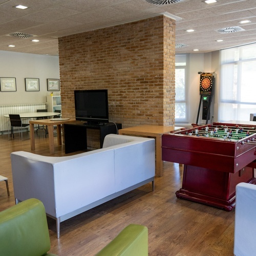 a room with a couch a table and a dart board