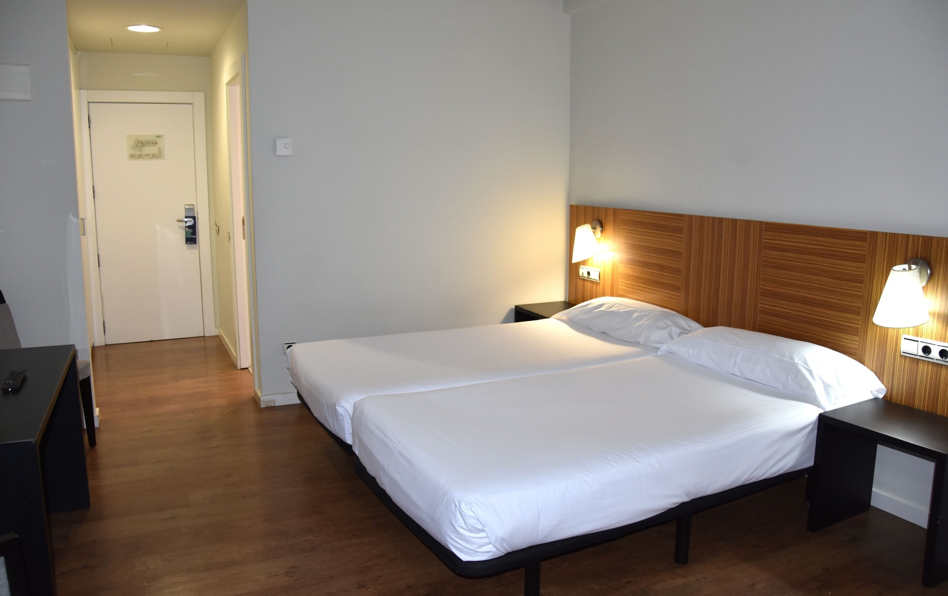 une chambre d' hôtel avec deux lits et une porte d' entrée