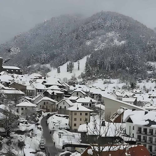 un pueblo cubierto de nieve con un edificio con la palabra hotel en la parte superior