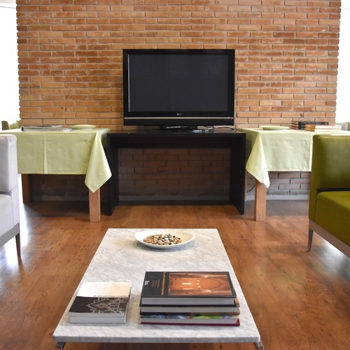 a stack of books sits on a table in front of a flat screen tv