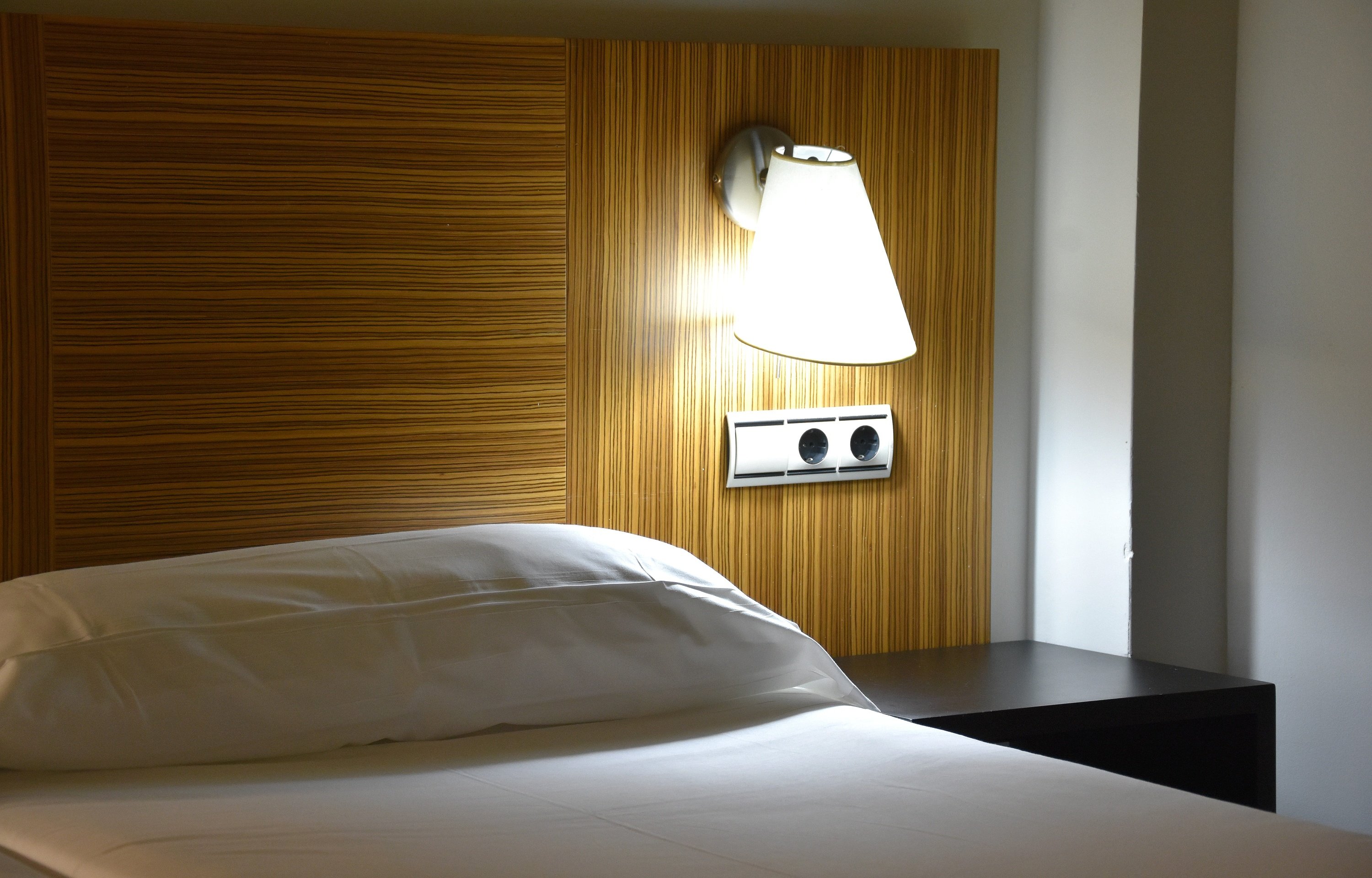 una habitación con una cama y una lámpara en la pared