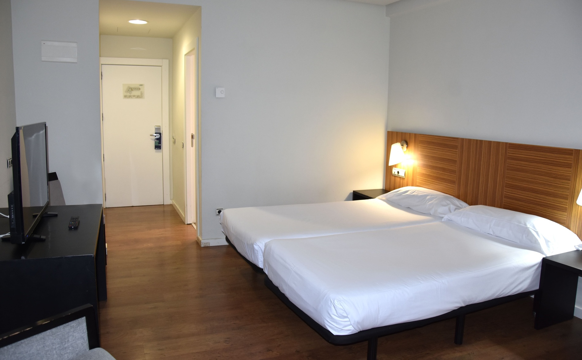 une chambre d' hôtel avec deux lits et une porte blanche