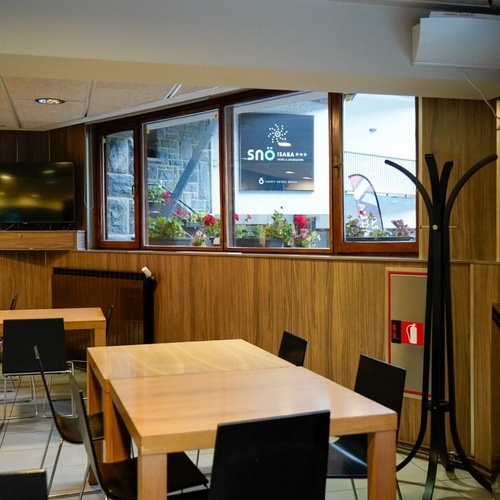 a room with tables and chairs and a sign that says sno
