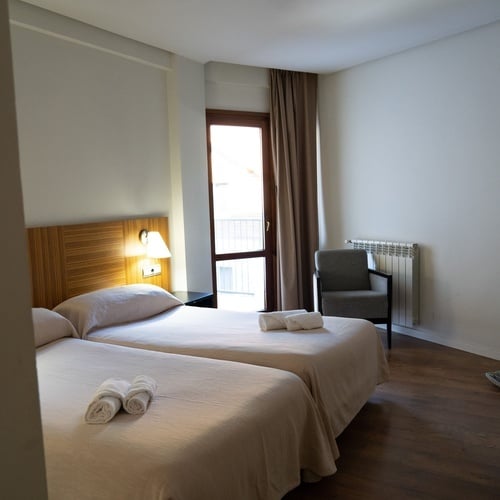a hotel room with two beds and a tv