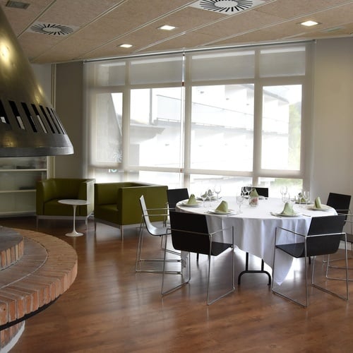 a room with tables and chairs and a fireplace