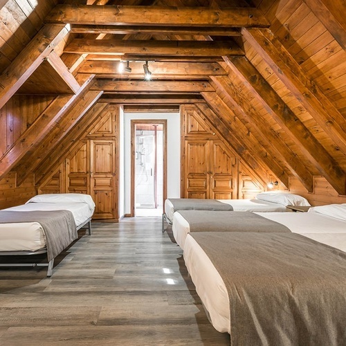 a bedroom with four beds and a wooden ceiling