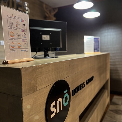 Una recepció d'hotel de fusta amb el logo 