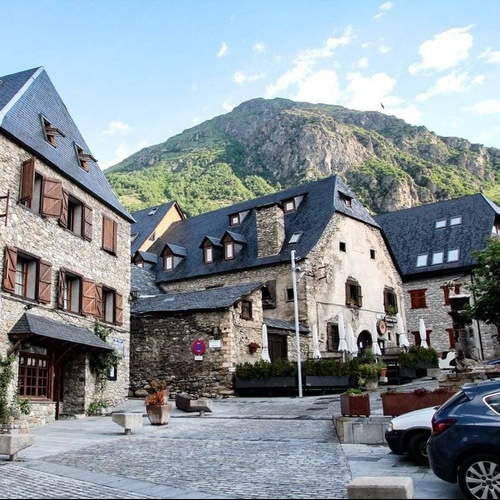 un pequeño pueblo de montaña con edificios de piedra y techos de tejas