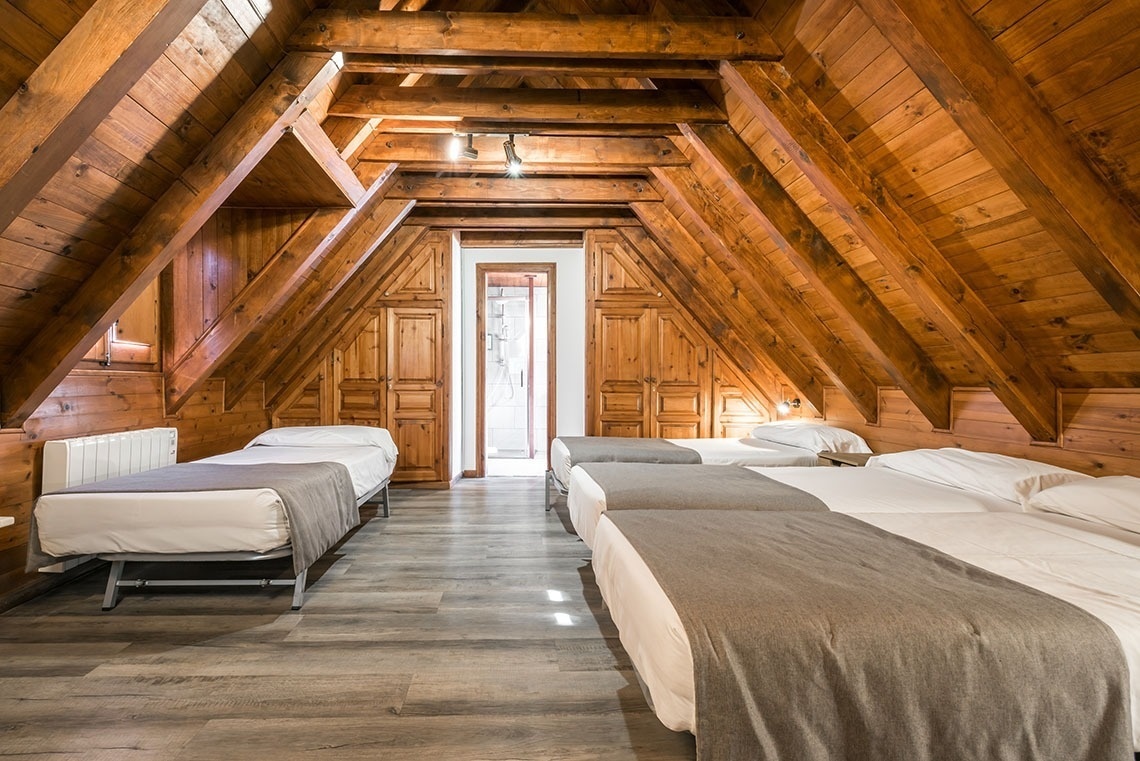 un quart d' habitació amb tres camas i un radiador