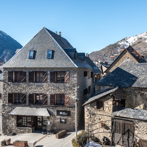 un bâtiment en pierre avec un toit en ardoise à côté d' un autre bâtiment