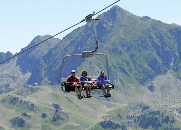tres persones s'encarreguen en un ascensor a la montagna