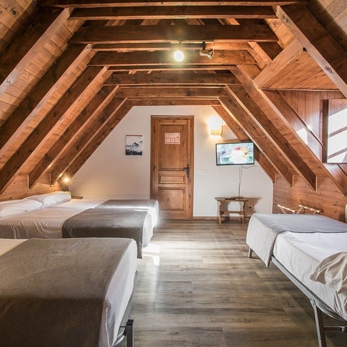 a room with three beds and a tv on the wall