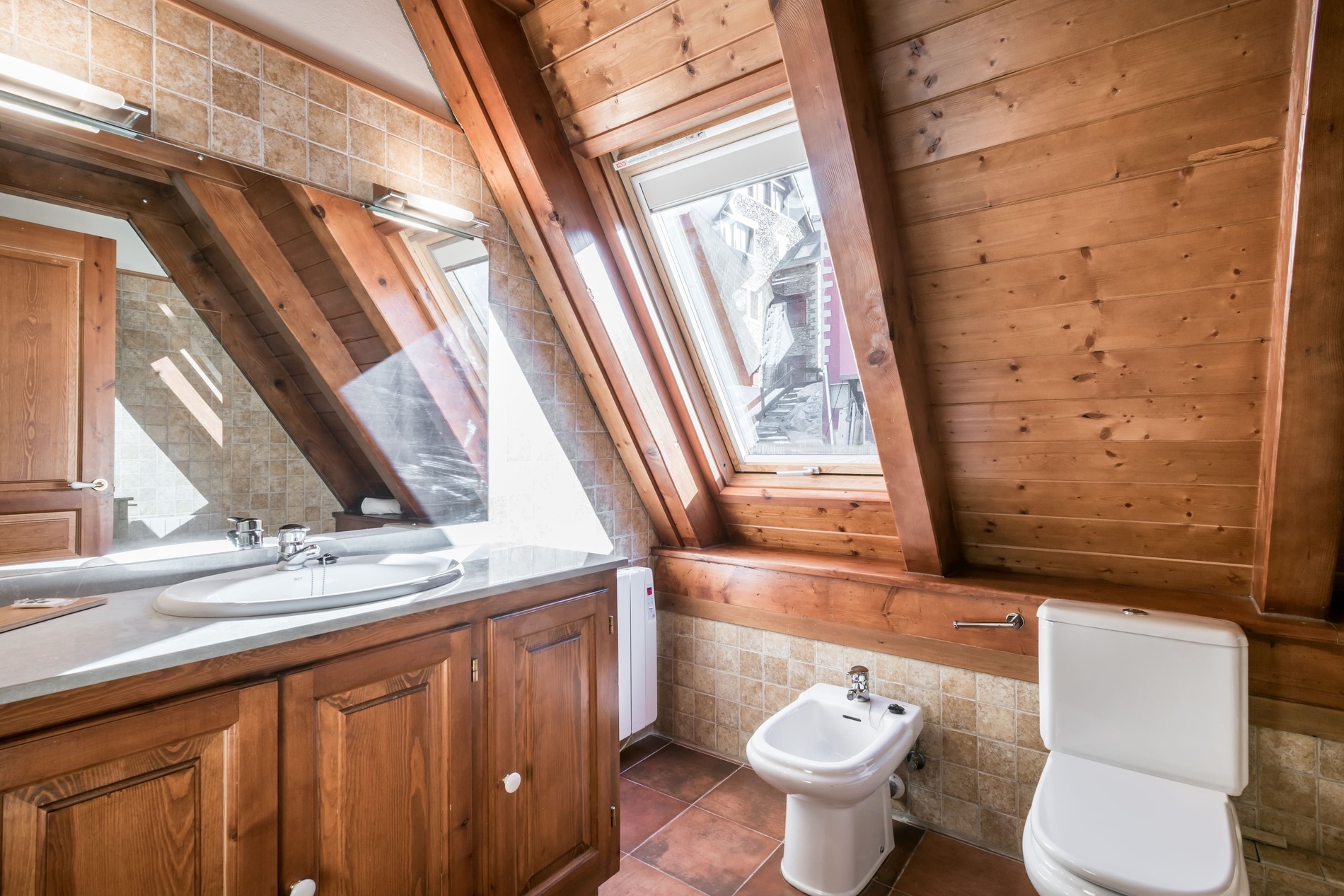 un baño de madera con un inodoro y un lavabo