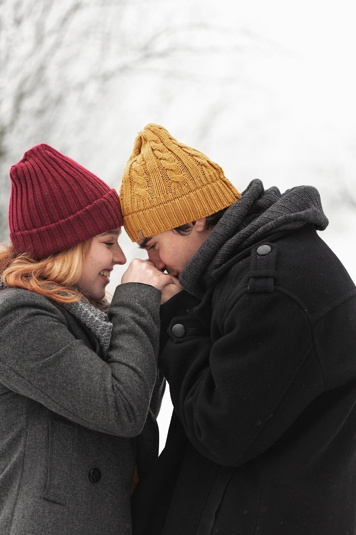 a man and a woman holding hands in the snow