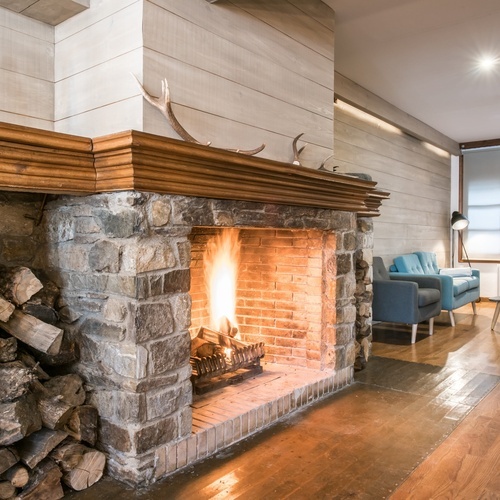 a living room with a fireplace and a christmas tree on the mantle