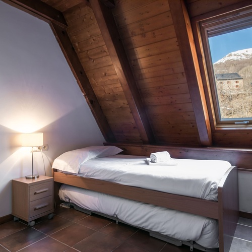 une chambre avec un lit et une fenêtre avec vue sur les montagnes