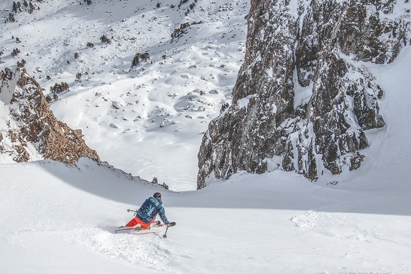 un esquiador s'envolta en la nieve a l' alça d' una roca
