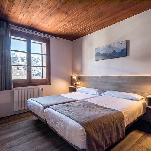 a bedroom with two beds and a painting on the wall
