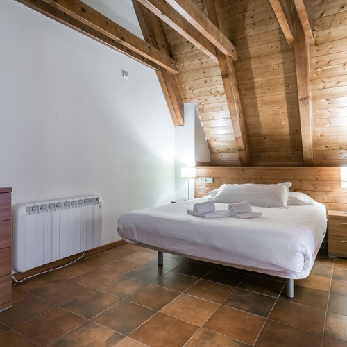 un dormitori de fusta amb una cama i un radiador