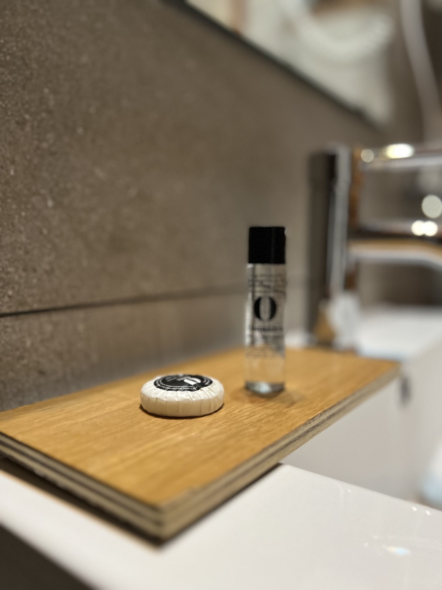 a bottle with the letter o on it sits on a wooden tray