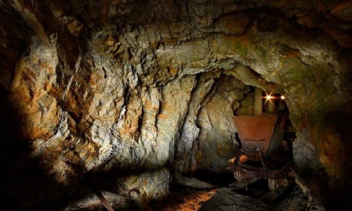 una cueva llena de rocas y rocas con un carro en la entrada .