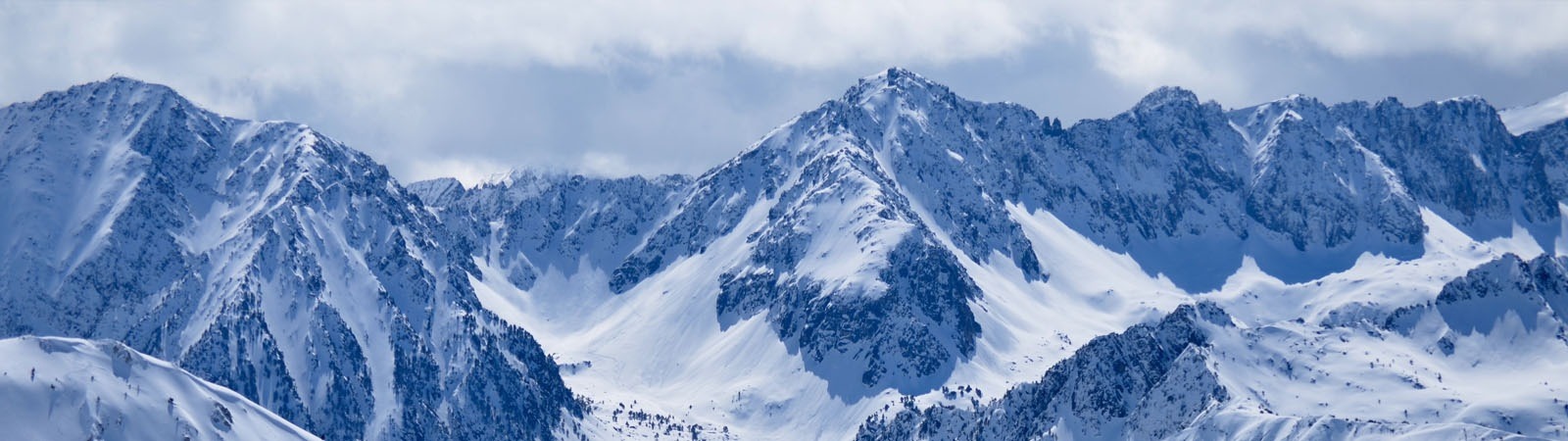 montañas cubiertas de nieve con un cielo azul en el fondo