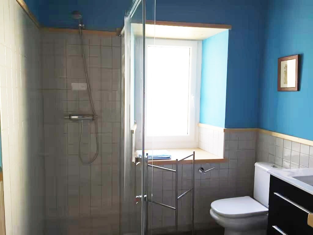 un baño con paredes azules y un inodoro y ducha