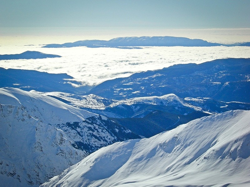 un paisatge de montagnes cobertes de neige avec des nuages en arrière-plan