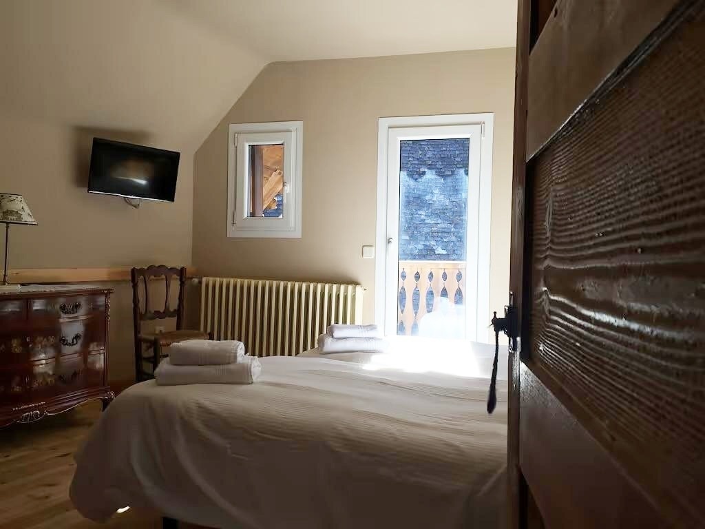 una habitación con una cama y una televisión en la pared